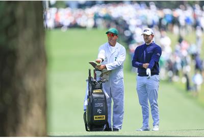 Patrick Cantlay consults with his caddie during the final round of the 2023 Masters.