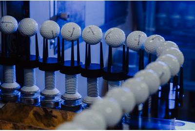 Golf balls on the paint line inside the TaylorMade golf ball plant