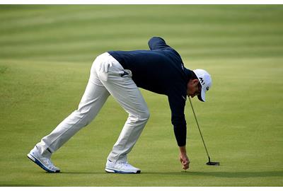 Justin Rose repairs a pitch mark